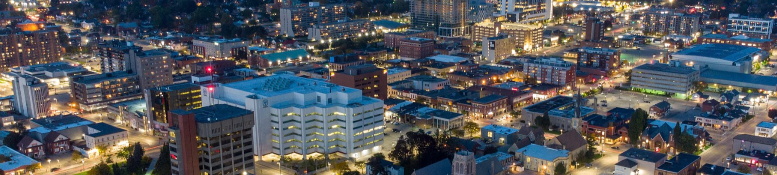 Image of downtown oshawa from above at night. Street lights illuminate the streets, with residential and office buildings in the background.