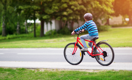 child riding a bicycle on a path