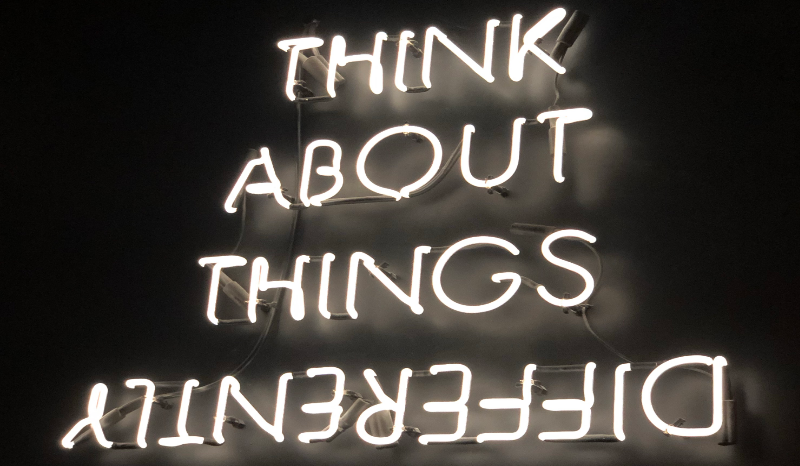 Neon Sign reading "Think About Things Differently"