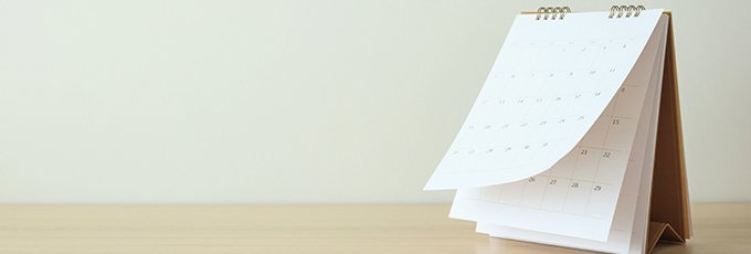 Calendar standing on an empty desk with the top page blowing upwards