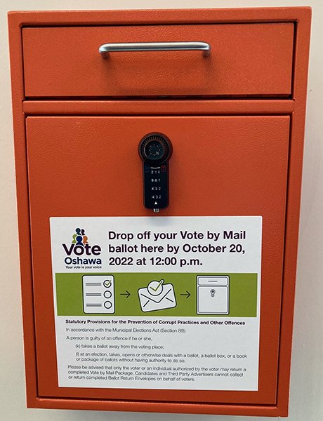 Orange envelope drop-box with Vote Oshawa sticker on the front