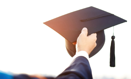 Hand holding a mortarboard hat