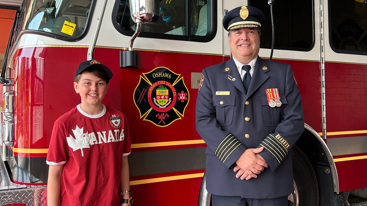 Mary and Fire Chief Clark standing in front of a fire truck.