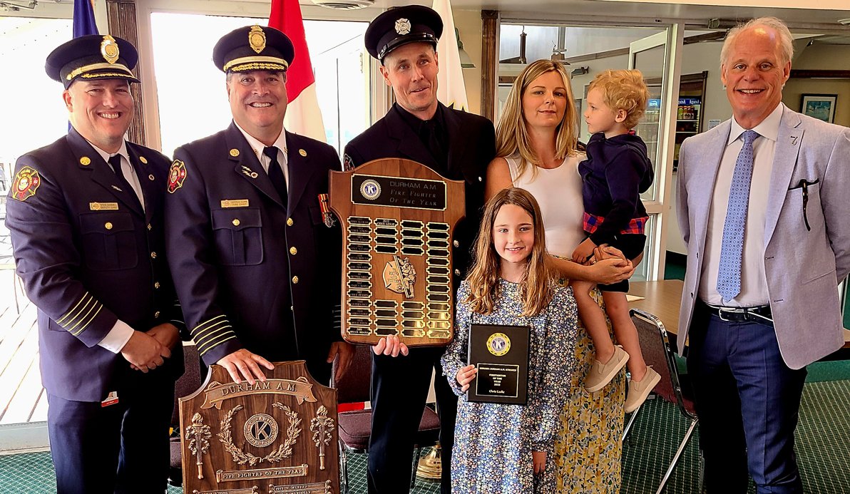 Deputy Chief Stephen Barkwell, Chief Derrick Clark and Mayor Dan Carter stand beside Chris Leslie and his family as he accepts the Firefighter of the Year Award.