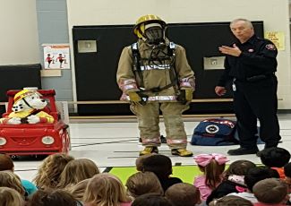 Fire Prevention Inspector presenting to children with Firefighter in Bunker gear