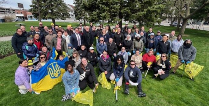 Group of people surround Oshawa Mayor Carter as they prepare for a community clean up.
