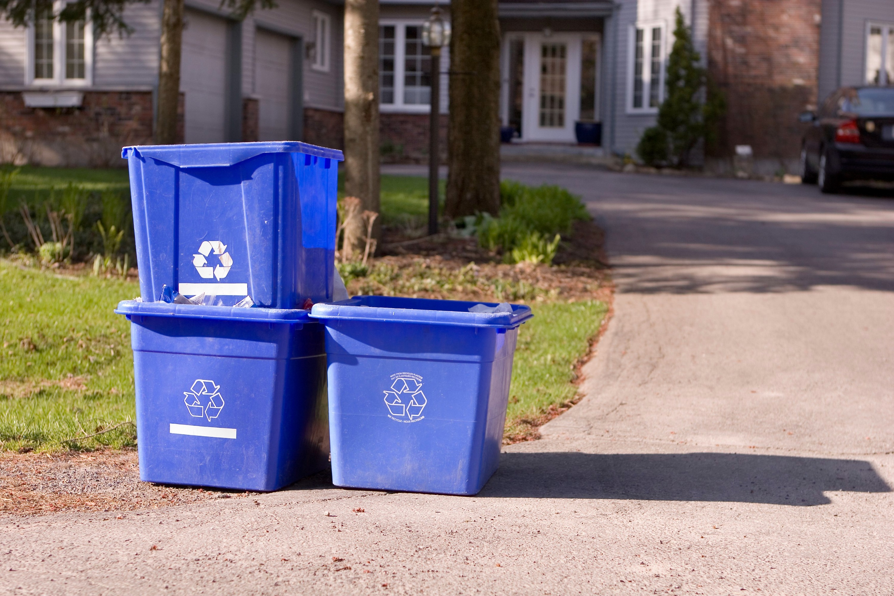 blue boxes set out at the curb for collection