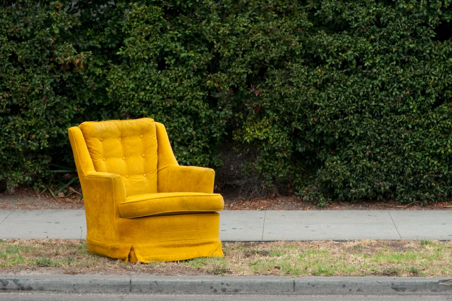 yellow arm chair set out at the curb for collection