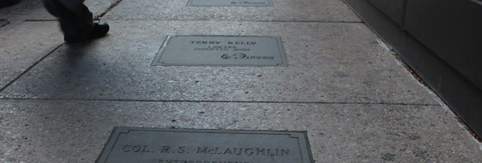 Feet walking beside a section of the Oshawa Walk of Fame