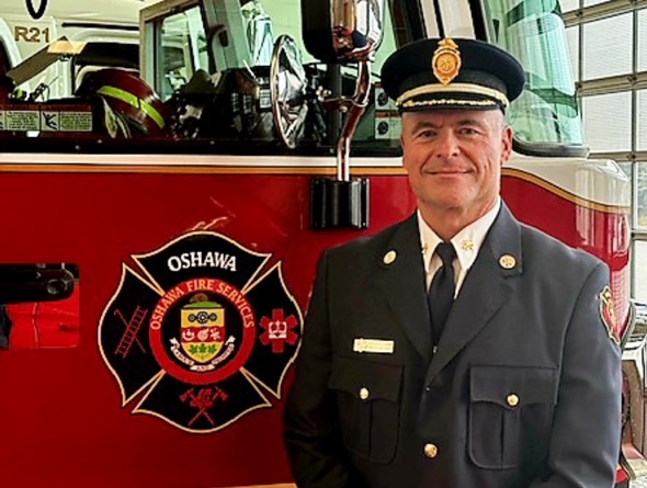 Deputy Chief Whetham stands in front of fire truck