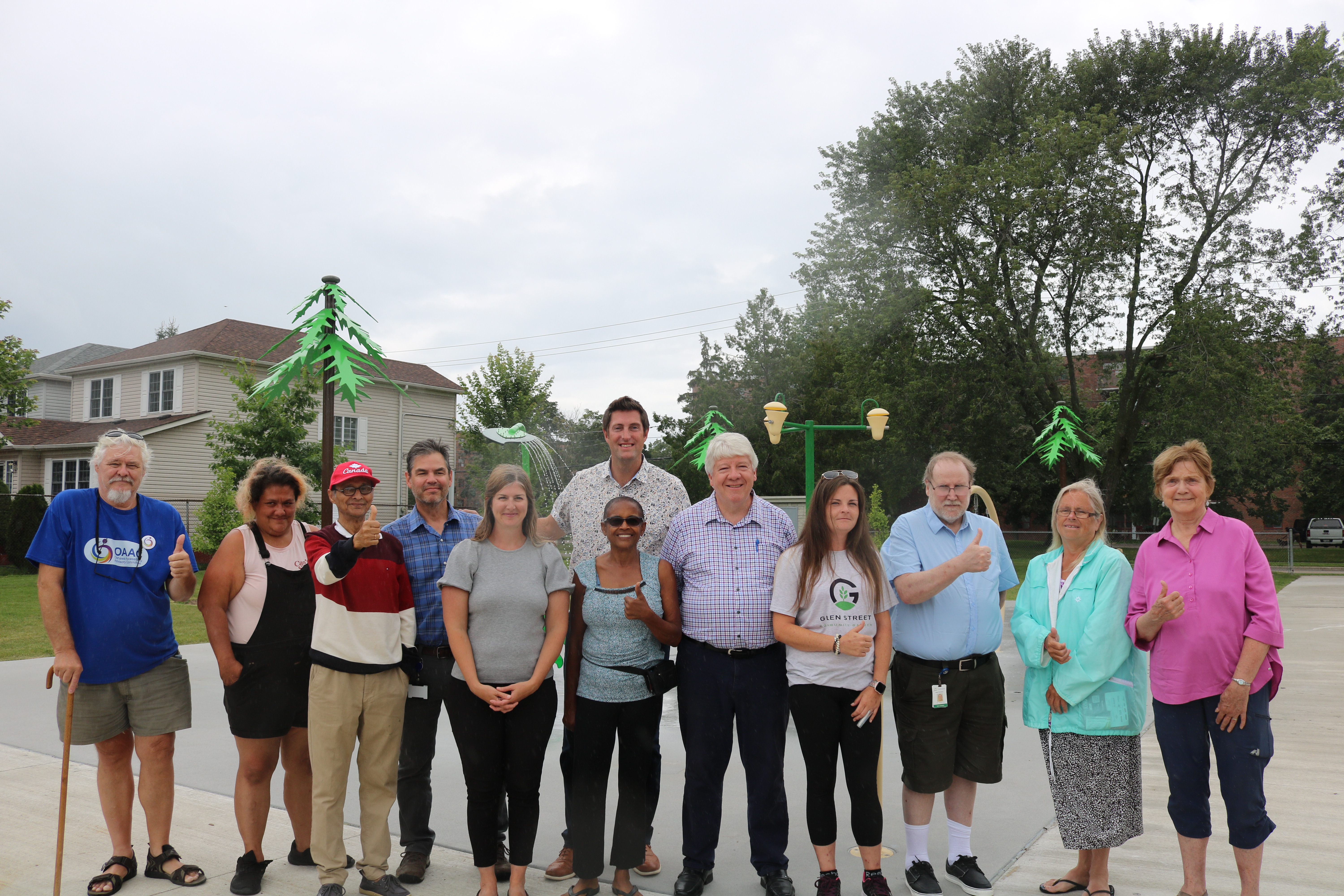 Ryan Turnbull, Member of Parliament for Whitby, on behalf of the Honourable Sean Fraser, Minister of Housing, Infrastructure and Communities, with members of Oshawa City Council and neighbourhood residents, stand in front of the new splashpad at Cordova Valley Park