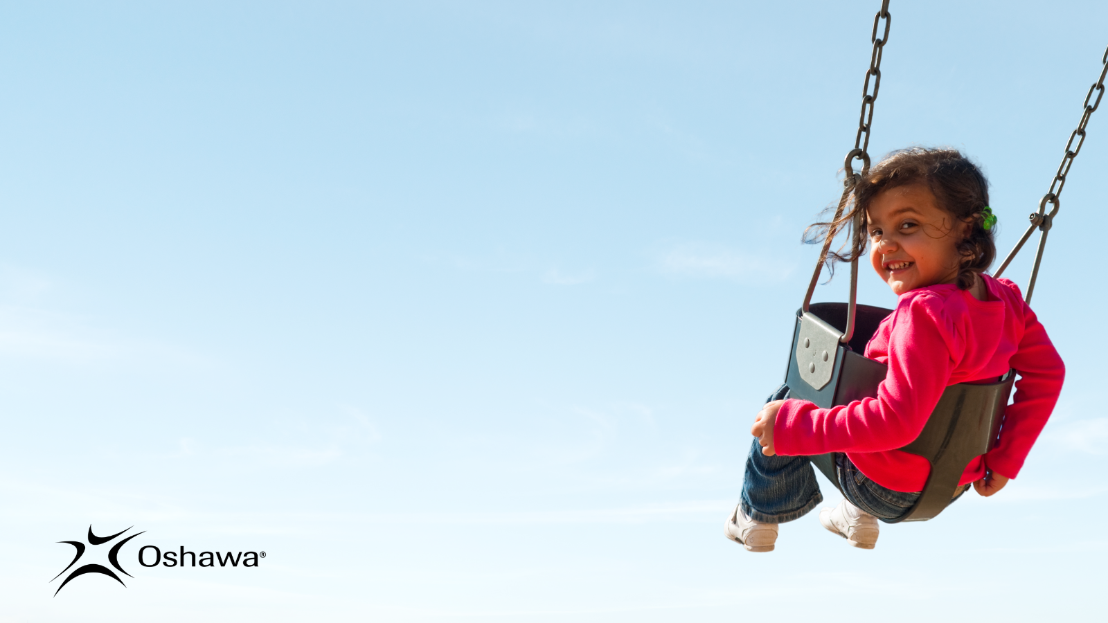 Female toddler on swing looking over shoulder