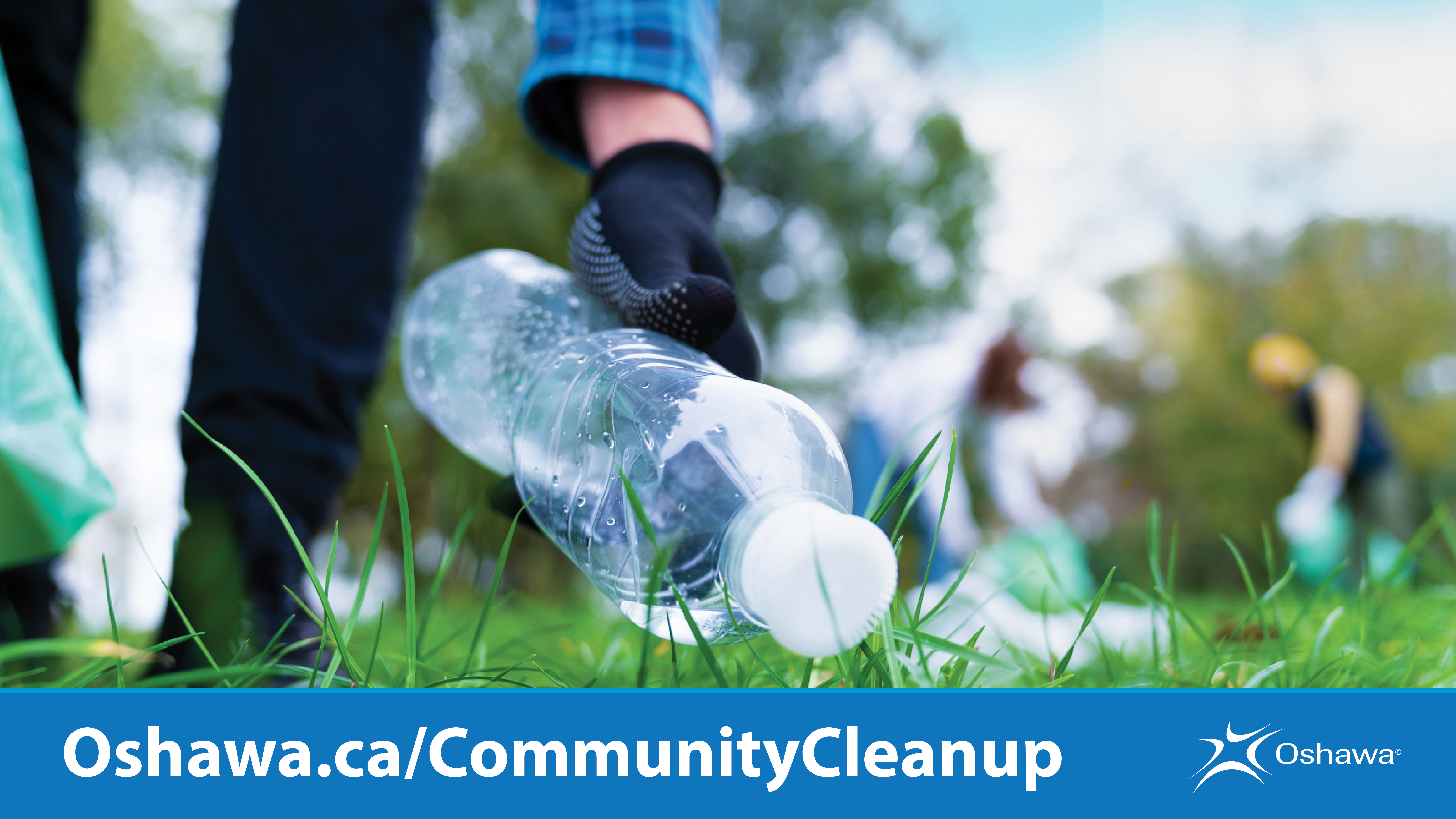 Gloved hand picking up plastic water bottle off the ground