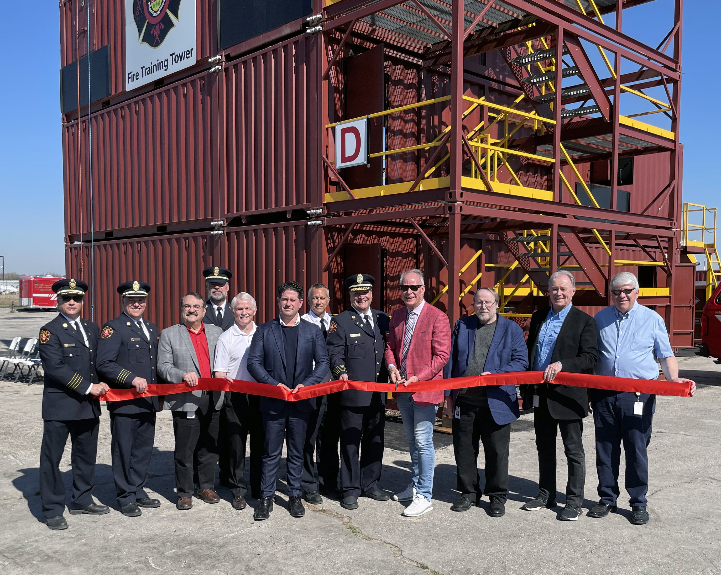 Members of City Council and Oshawa Fire Services cut the ribbon in front of the new fire training facility