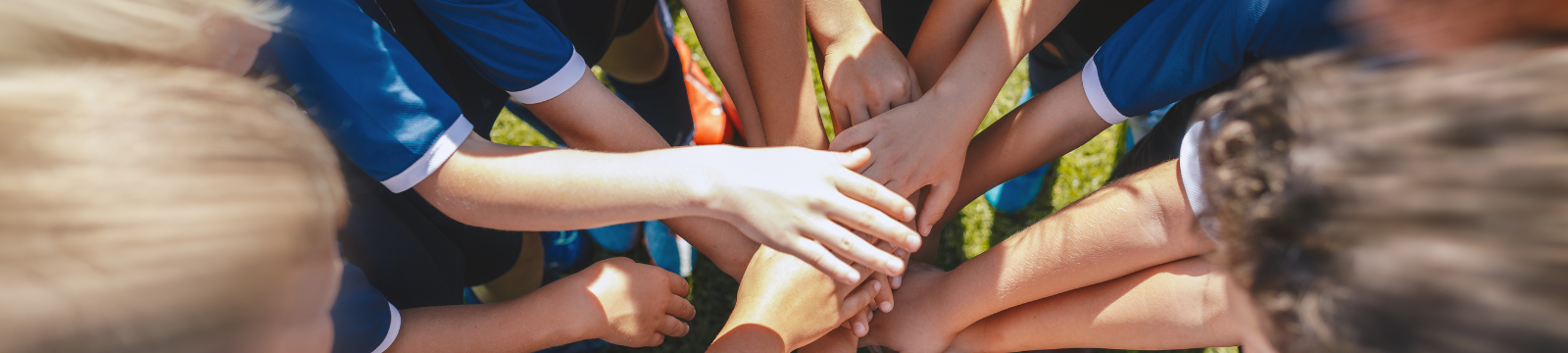 Youth sports team with hands in the middle