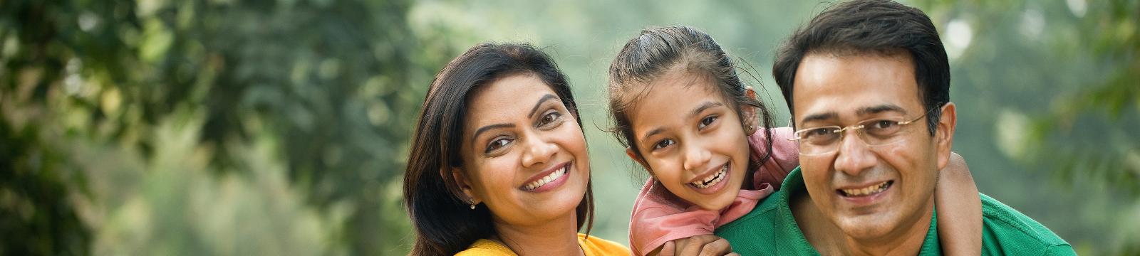 Couple with child smiling in the park