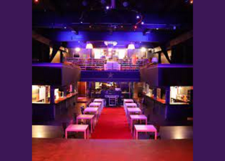 bars on either side with tables and chairs looking out from a stage