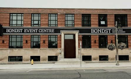 Exterior image of brown brick building with black windows and Bond Street Event Centre signage.