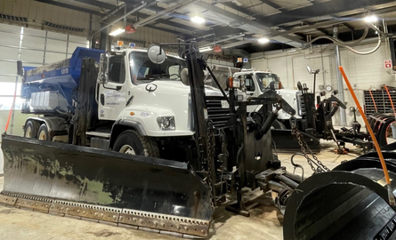 Oversize snowplow in fleet garage.