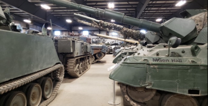 Regiment Museum sign with military vehicles in the back