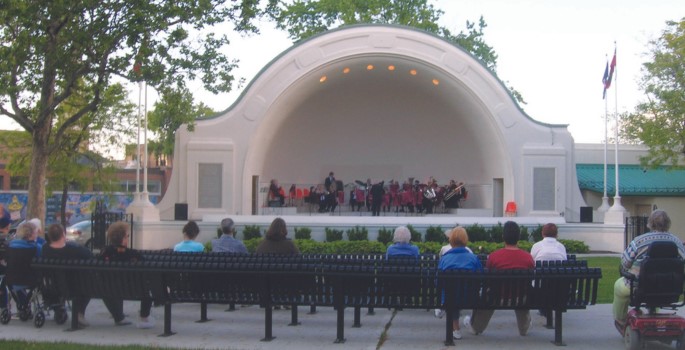 Rows of seating in front of McLaughlin bandshell as band performs on stage to onlooking crowd