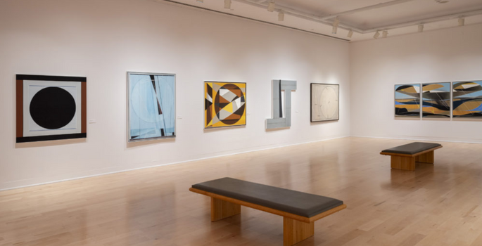 Gallery pictures on walls with a bench