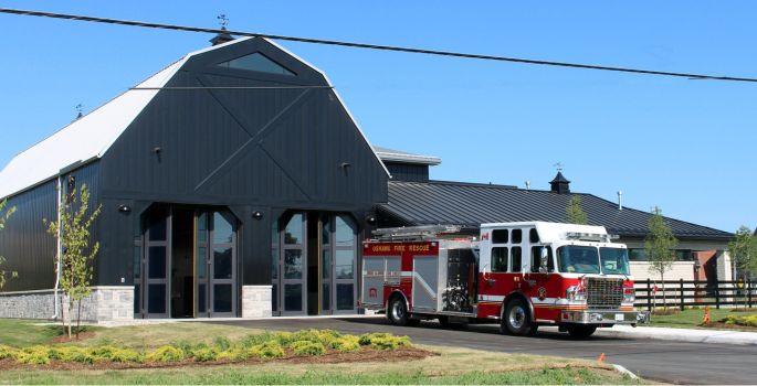 Modern Farm house style building with glass garage doors and fire truck parked out front
