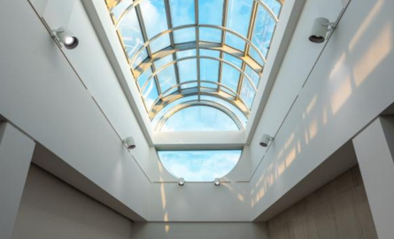 Interior image of skylights, looking upwards at arched glass windows.