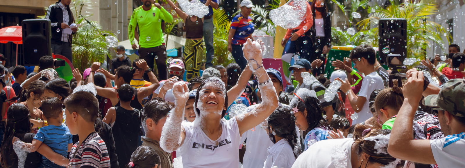 Smiling people with foam on them in front of a stage