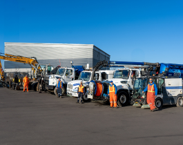 Oversize City of Oshawa vehicles and machines lined up with Operations Staff in orange and blue uniforms in front.