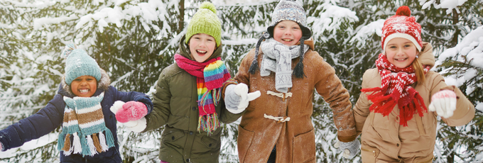Children smiling in a snowy forest
