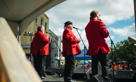 3 men on a stage singing 