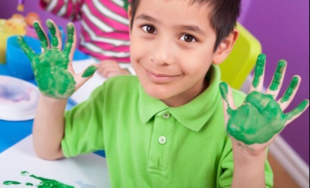 A kid with hands painted green