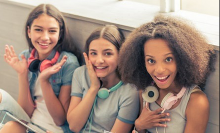 Three girls wearing headphones