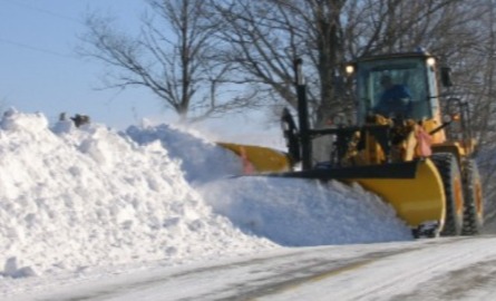 A loader plowing the street
