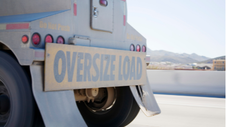 A transport truck marked with and oversize load 