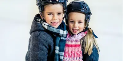 Boy and girl smiling in hockey helmets