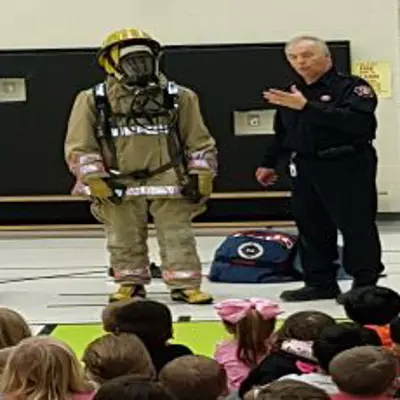 Firefighter talking at a school assembly