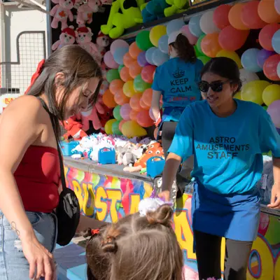 woman and child at carnival balloon game