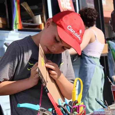 boy making a craft at art bus