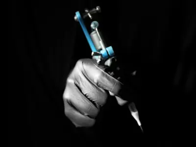 Hand holding tattoo gun