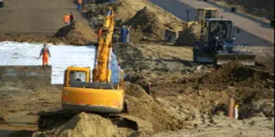large yellow excavator moving dirt