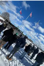 students at Ed Broadbent Park in front of main saign