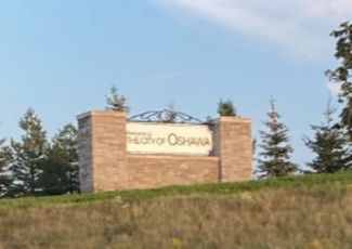 brick and stone Oshawa sign on a grass knoll
