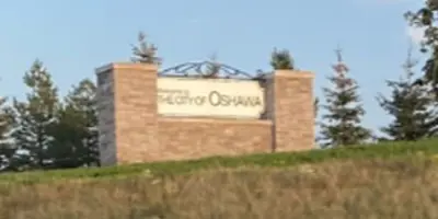 brick and stone Oshawa sign on a grass knoll