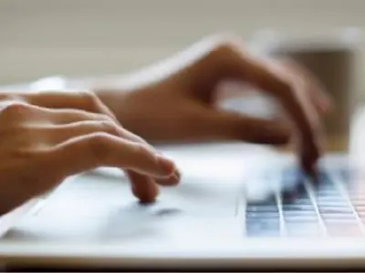 hands typing on laptop keyboard