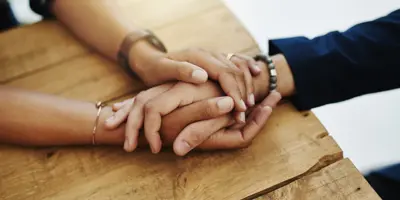 People holding hands on a table