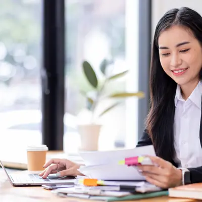 Woman Reviewing Documents At Computer