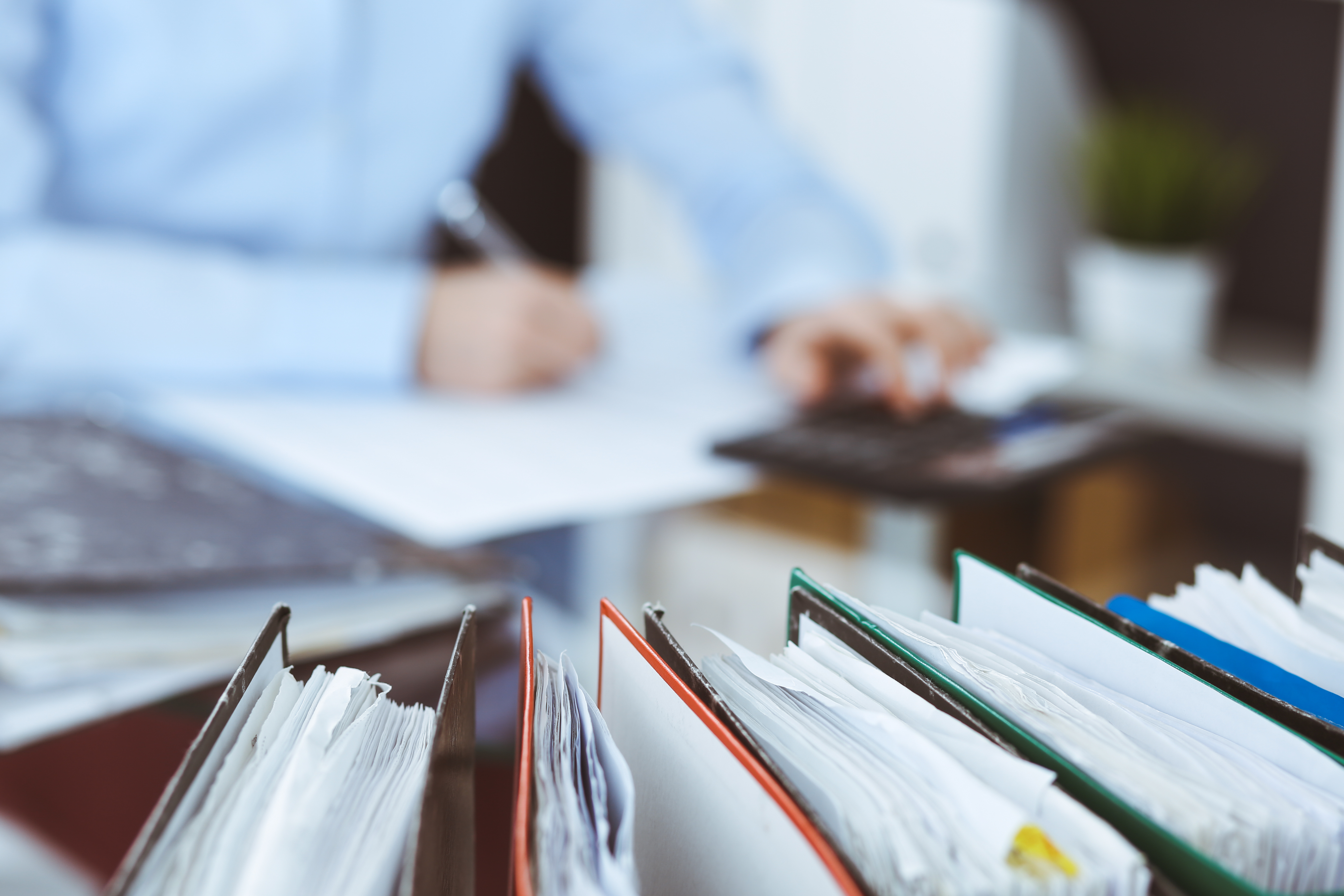 Person working at a desk with binders in front of them 