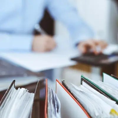 Person working at a desk with binders in front of them
